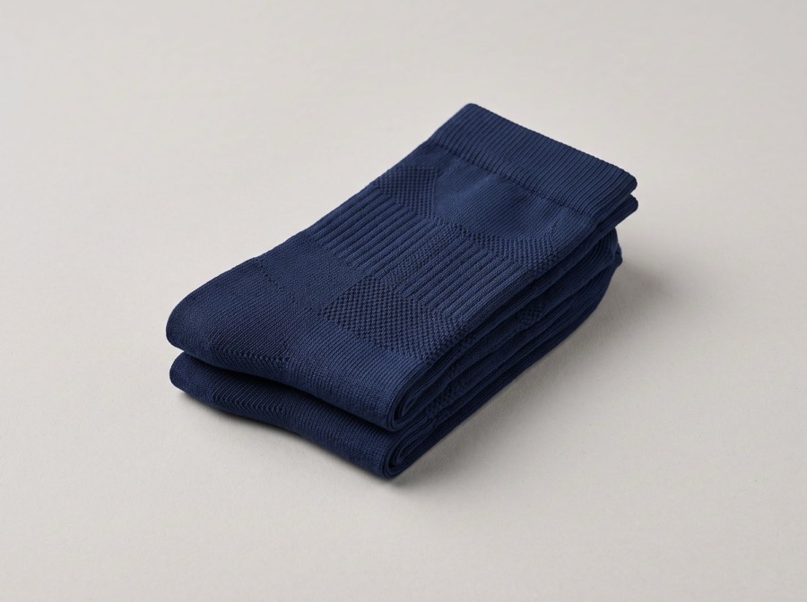 Folded pair of navy compression arch support socks